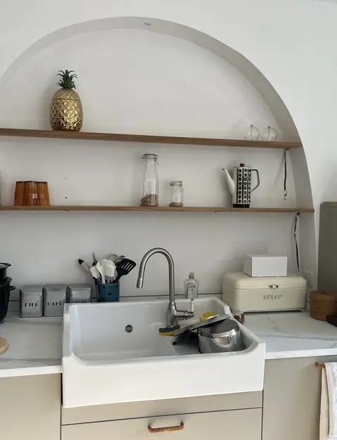 Cuisine rénovée sous une arche avec étagères et évier en céramique à Saint-Raphaël
